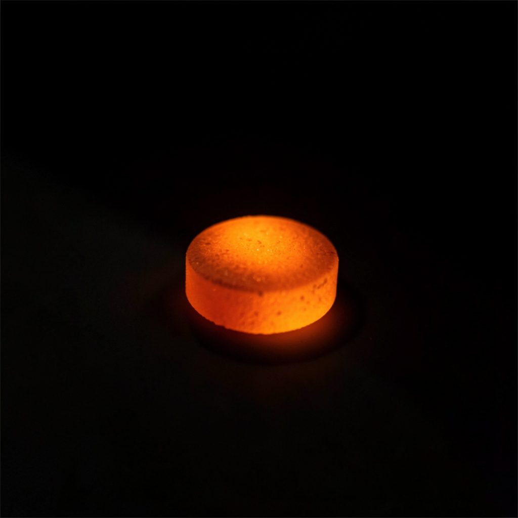 Small dark-toned edible gummy pieces arranged against a shadowy backdrop